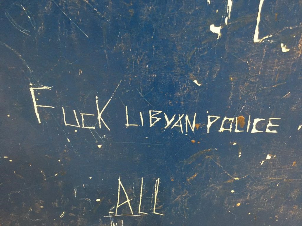Fuck Libyan police written on a blue wall