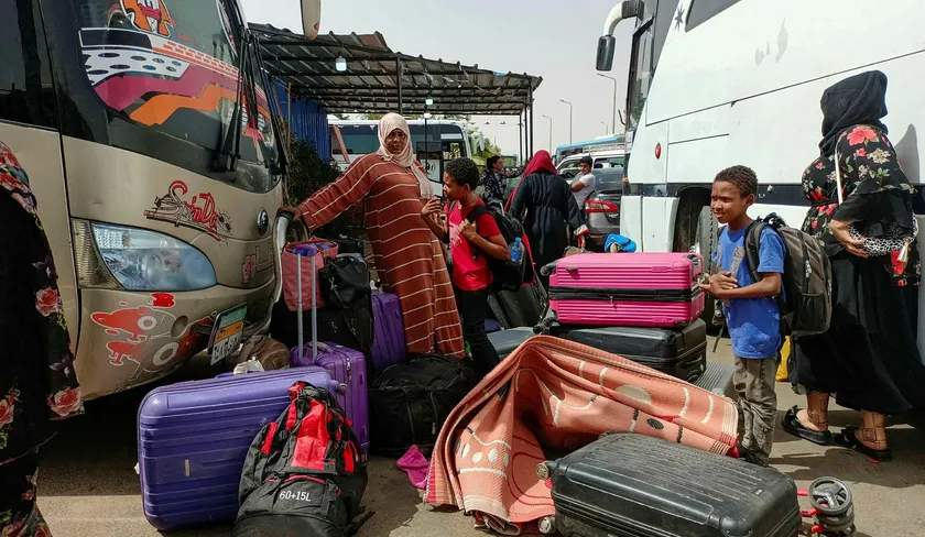 PHOTO: Passengers fleeing armed conflict in Sudan disembark at the Wadi Karkar bus station near the Egyptian city of Aswan, on Wednesday. AFP