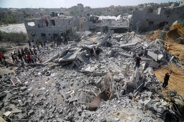 عمال الإنقاذ يبحثون في المباني المدمرة مع استمرار الغارات الجوية الإسرائيلية في اليوم السادس من العدوان الإسرائيلي يوم الخميس بغزة. تصوير: وكالة الأناضول/ Getty Images